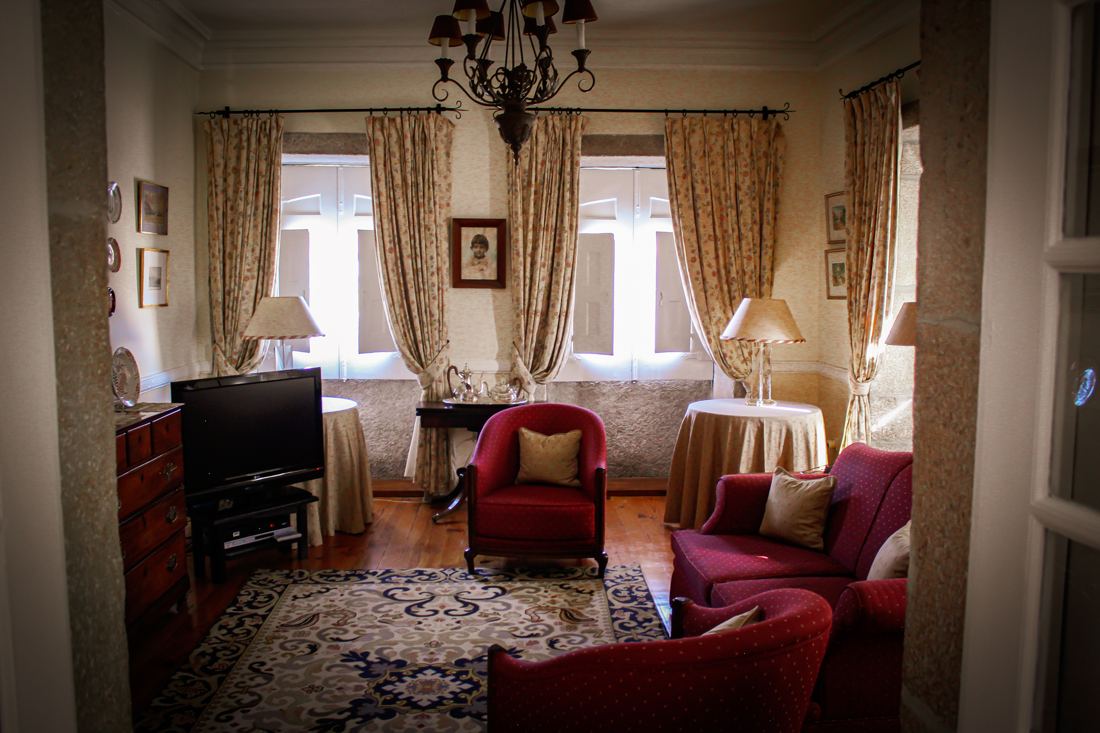 Sala de estar com sofás vermelhos e cortinados